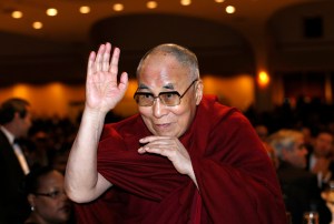 The Dalai Lama waves towards the head table, where U.S. President Barack Obama was seated, during the National Prayer Breakfast in Washington